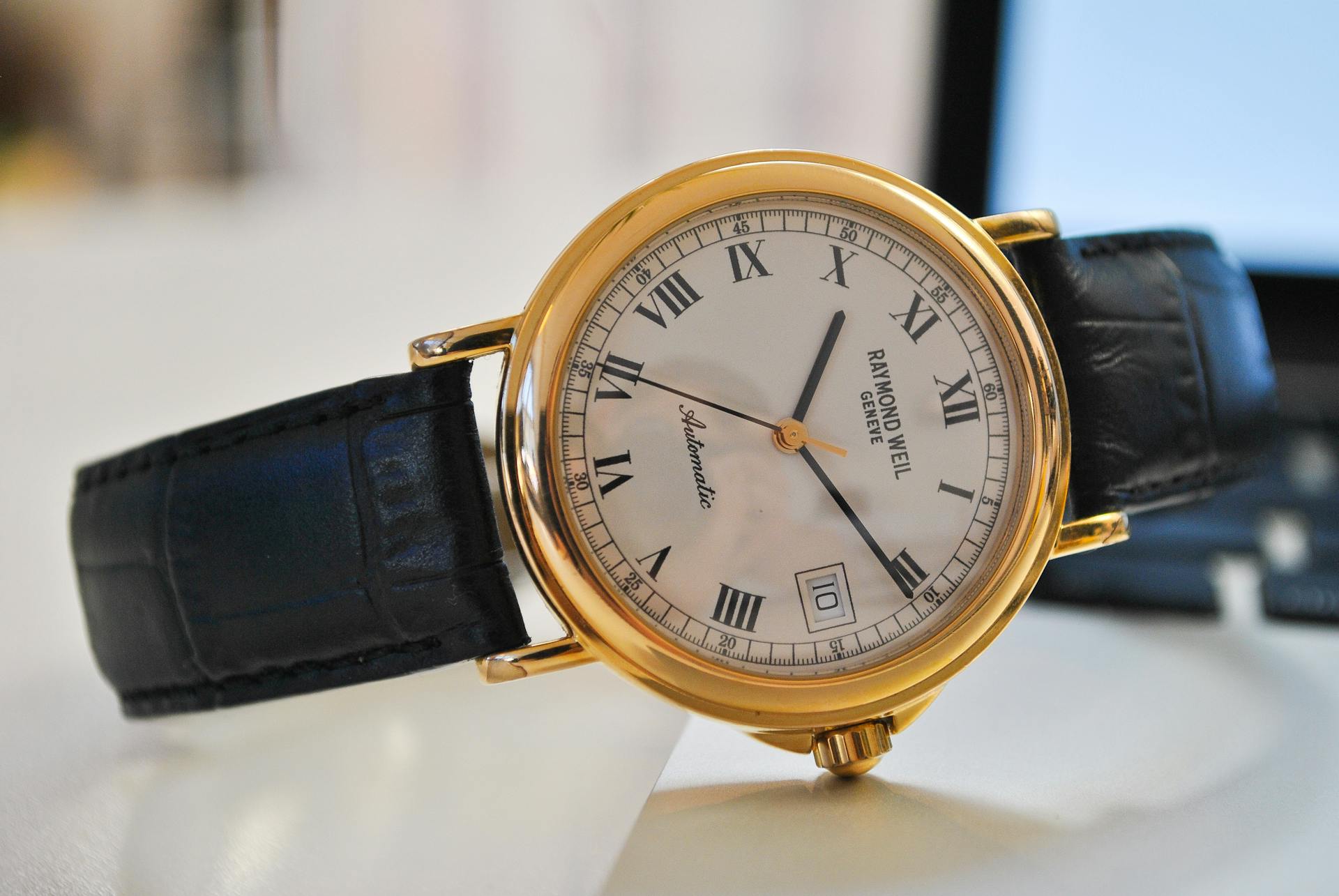 Antique gold watch with black leather strap